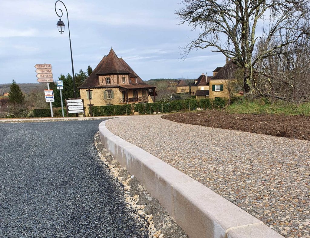 Bordure en pierre naturelle installée en courbe dans un aménagement de voirie à Beaumont-en-Périgord (24)