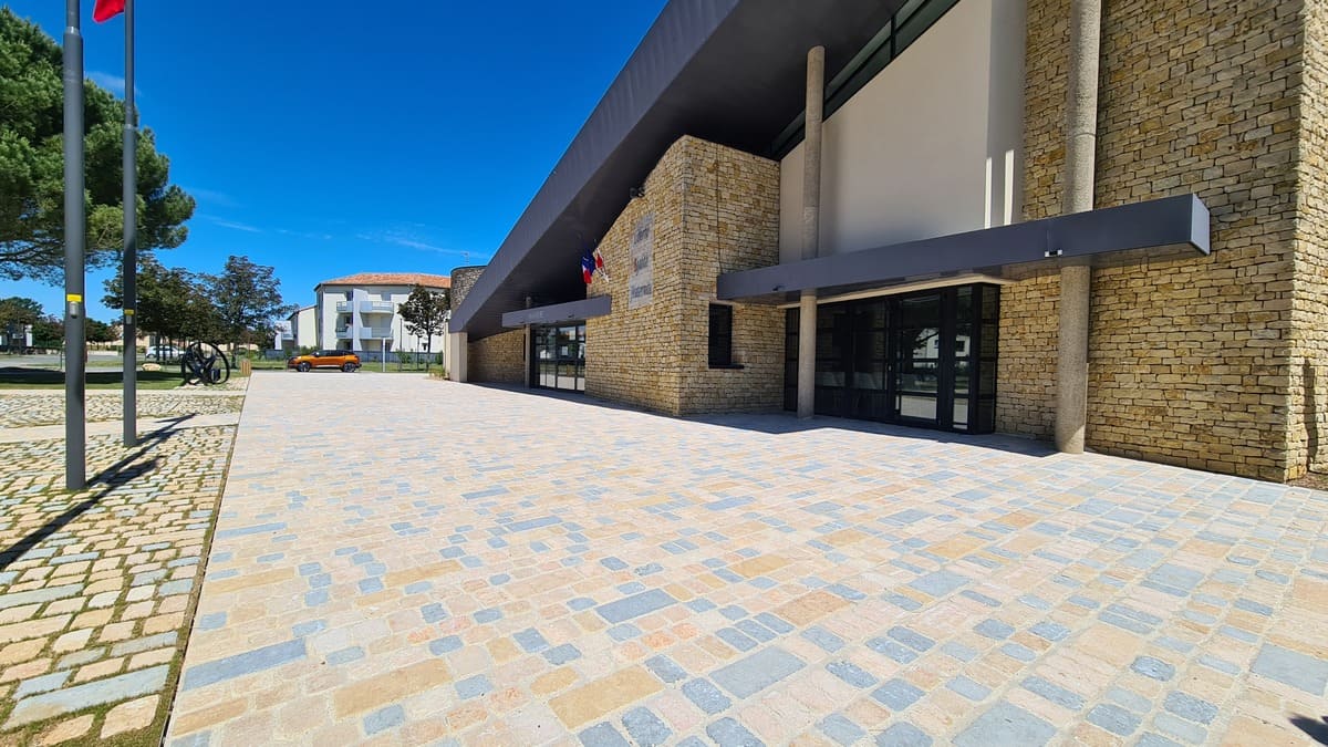Façade de la mairie de Fontaine-le-Comte habillée en moellons calcaire Calminia, avec parvis en pavés pierre naturelle Type Pavés Bout du Monde®